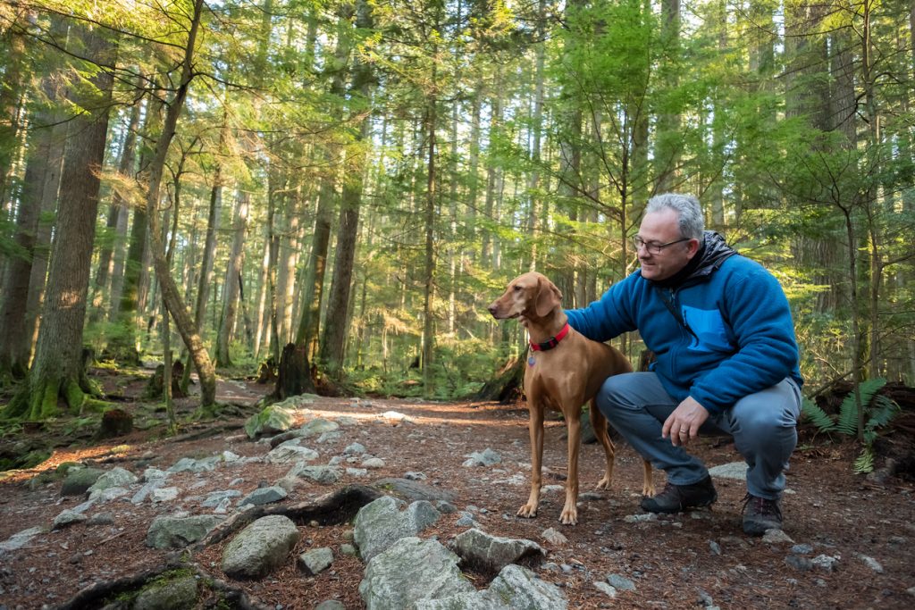 older man taking his dog for a hike